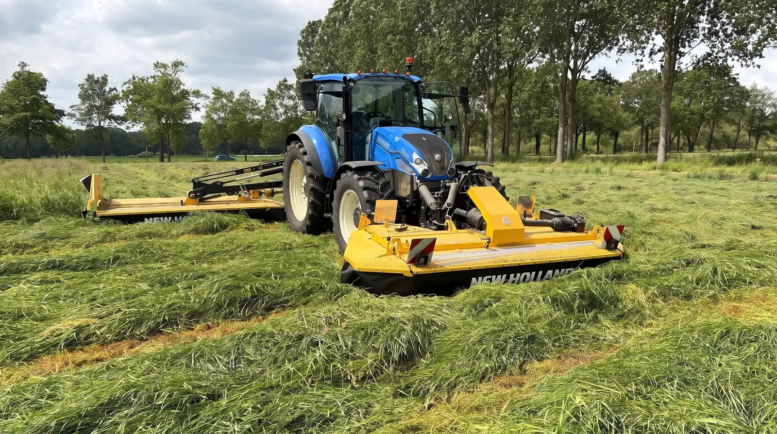 Een trekker maait het gras op het land van Van Vlerken